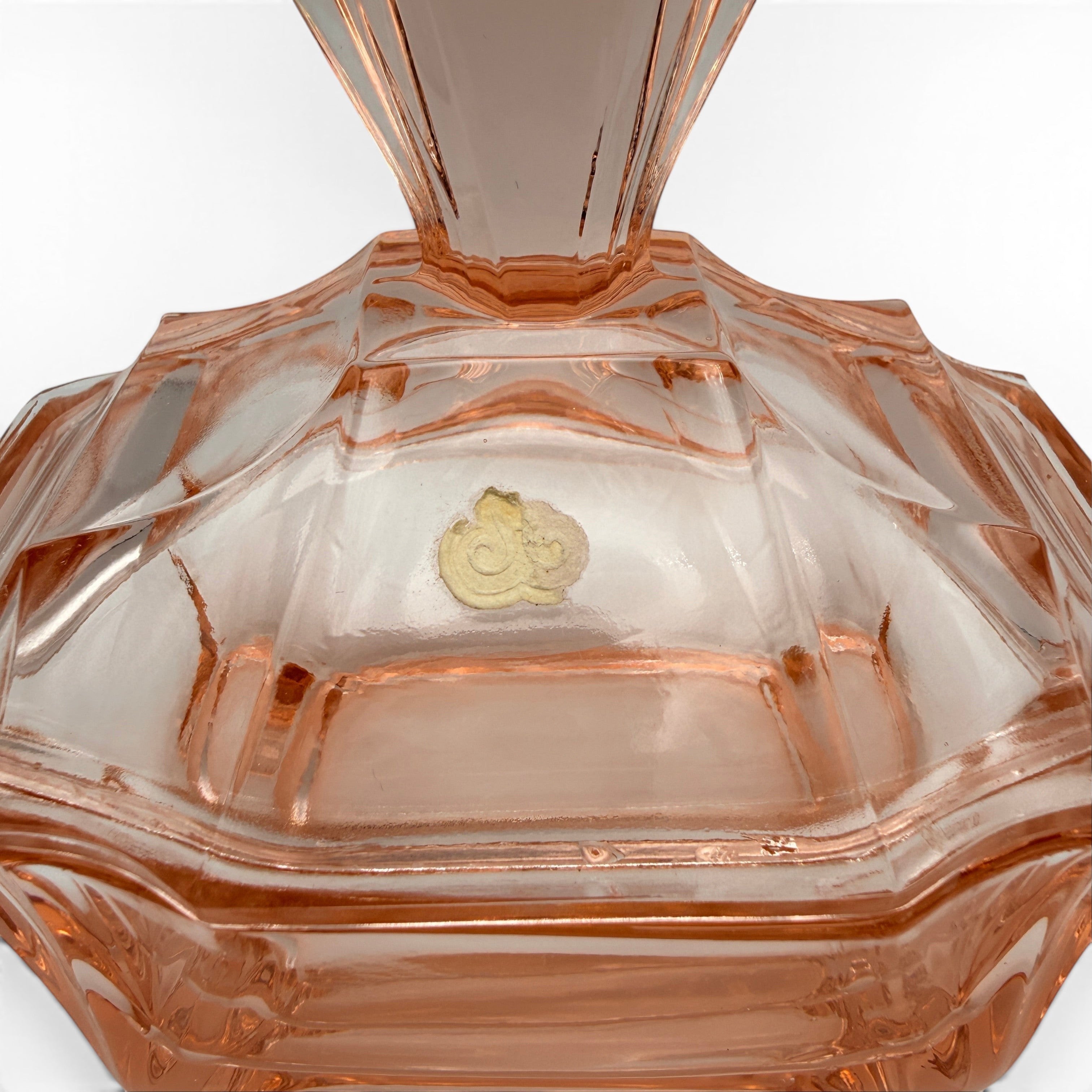 Showroom Ansbach Art Deco Puderdose aus lachsrosa Rosalinglas mit geometrischer Fächerform und Vintage-Etikett