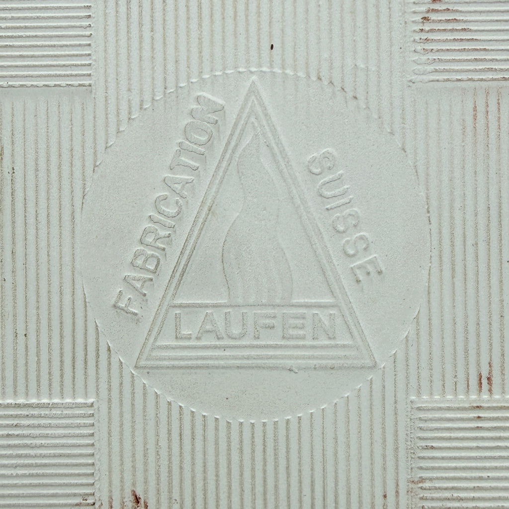 Showroom Ansbach Keramikfliese mit eingeprägtem Laufen Fabrication Suisse Logo auf cremeweißer, texturierter Oberfläche