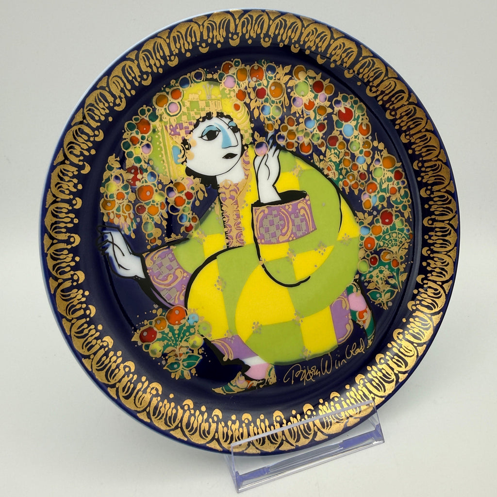 Showroom Ansbach dekorativer Porzellanteller mit stilisierter Figur in Gelb und Grün auf Blau mit Goldrand
