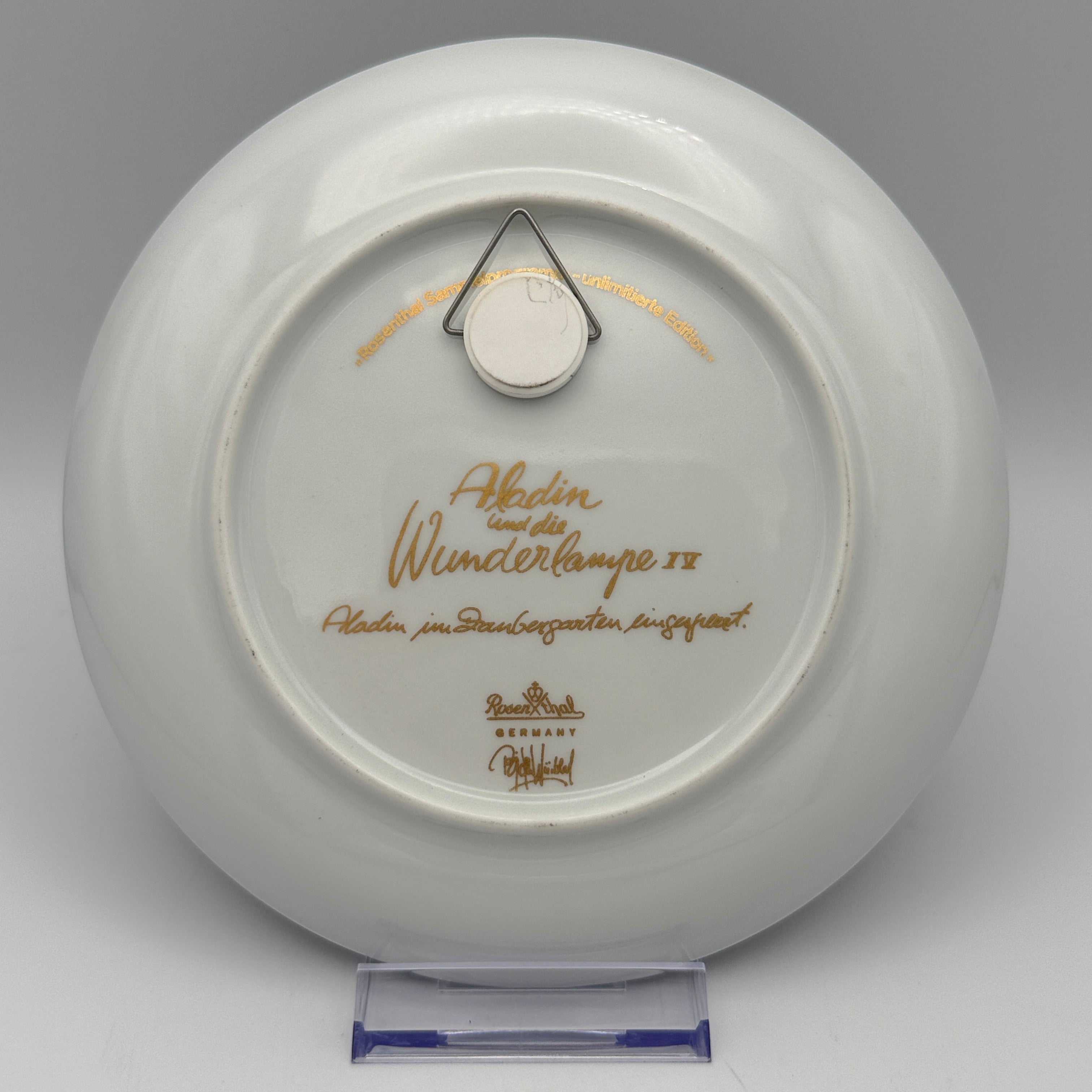 Rückseite eines Showroom Ansbach Porzellantellers mit goldener Aladin und die Wunderlampe IV Inschrift und Wandhalterung